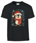 Barn-t-shirt i rött med gullig julpingvin i tomteluva och halsduk bland snöflingor.