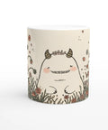 Mugg med blommor och ett troll som parodierar mumin. 