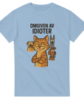 Lurig katt med hundar i bakgrunden och texten "OMGIVEN AV IDIOTER" på ljusblå t-shirt