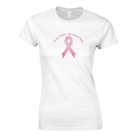 Vit dam-t-shirt med rosa band och texten “In October, We Wear Pink” – stödjer bröstcancermedvetenhet.