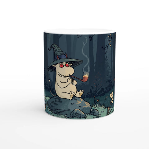 Rolig mugg med roligt stenat troll sittandes i en skog, humoristiskt motiv på vit mugg. Parodi på mumin.