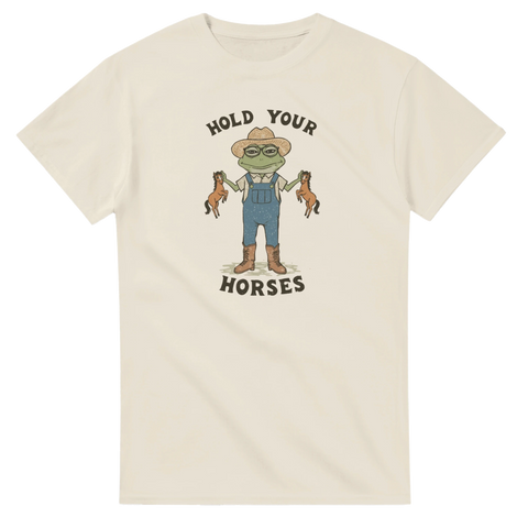 Beige t-shirt med tecknad groda som håller två små hästar och texten Hold Your Horses