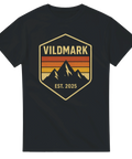 Svart t-shirt med badge och bergsmotiv samt texten “Vildmark – Est. 2025”
