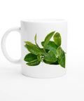 Vit mugg med tryck av gröna teblad i fräsch och minimalistisk design