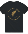 Svart t-shirt med elegant guldfärgad illustration av en fluga och texten "Fly Fishing – Handcrafted"